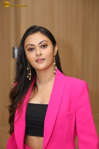 Tollywood actress megha chowdhury in a black top and pink overcoat