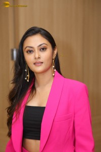 Tollywood actress megha chowdhury in a black top and pink overcoat