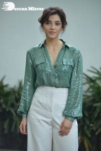 Actress Mehreen in green shirt and white pants