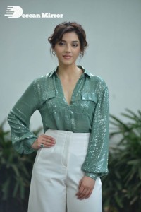 Actress Mehreen in green shirt and white pants