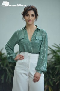Actress Mehreen in green shirt and white pants