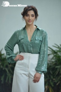 Actress Mehreen in green shirt and white pants
