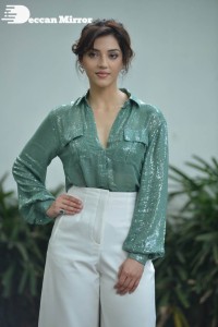 Actress Mehreen in green shirt and white pants