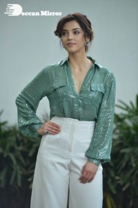 Actress Mehreen in green shirt and white pants
