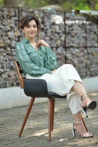Actress Mehreen in green shirt and white pants
