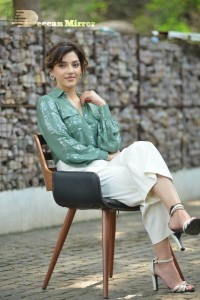 Actress Mehreen in green shirt and white pants