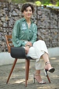 Actress Mehreen in green shirt and white pants