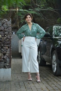Actress Mehreen in green shirt and white pants