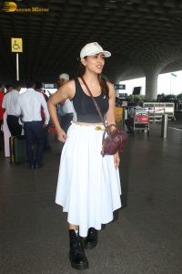 actress mrunal thakur in a black top and white skirt at airport