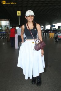 actress mrunal thakur in a black top and white skirt at airport
