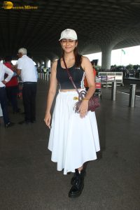 actress mrunal thakur in a black top and white skirt at airport