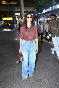 actress Mrunal Thakur in a brown shirt and blue denim jeans at airport