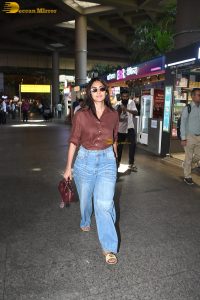 actress Mrunal Thakur in a brown shirt and blue denim jeans at airport