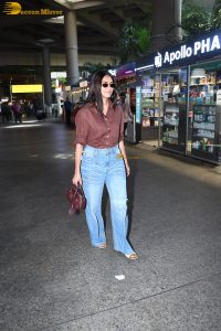 actress Mrunal Thakur in a brown shirt and blue denim jeans at airport