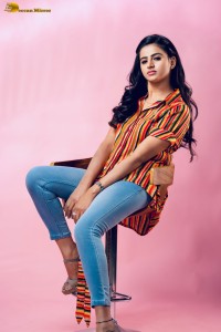 actress Naveena Reddy in a orange shirt and denim jeans