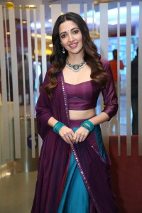 actress neha shetty in a low neck purple blouse