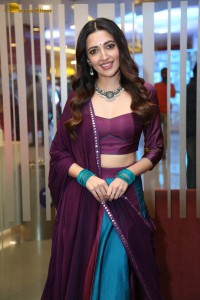 actress neha shetty in a low neck purple blouse