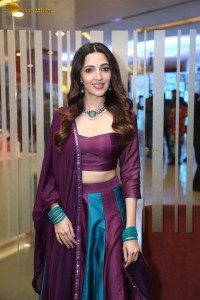 actress neha shetty in a low neck purple blouse