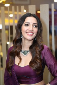 actress neha shetty in a low neck purple blouse