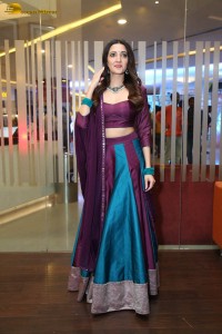 actress neha shetty in a low neck purple blouse