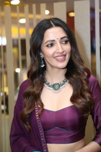 actress neha shetty in a low neck purple blouse