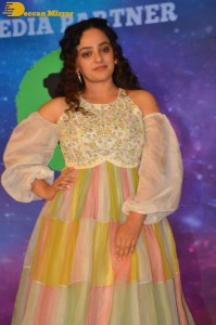 Nithya Menen in a white top and colorful skirt attending a movie function