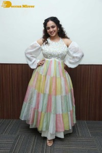 Nithya Menen in a white top and colorful skirt attending a movie function