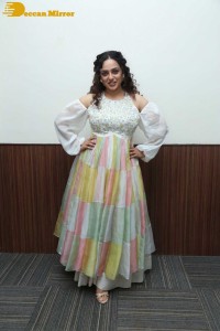 Nithya Menen in a white top and colorful skirt attending a movie function