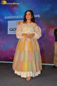 Nithya Menen in a white top and colorful skirt attending a movie function