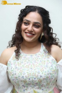 Nithya Menen in a white top and colorful skirt attending a movie function