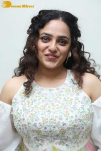 Nithya Menen in a white top and colorful skirt attending a movie function