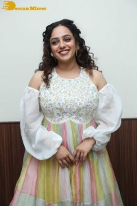 Nithya Menen in a white top and colorful skirt attending a movie function