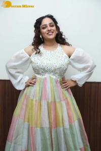 Nithya Menen in a white top and colorful skirt attending a movie function