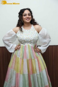 Nithya Menen in a white top and colorful skirt attending a movie function
