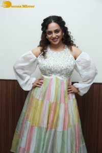 Nithya Menen in a white top and colorful skirt attending a movie function