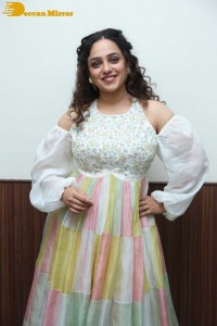 Nithya Menen in a white top and colorful skirt attending a movie function