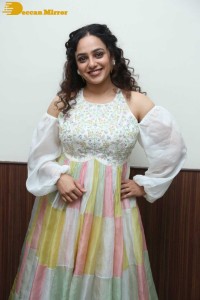 Nithya Menen in a white top and colorful skirt attending a movie function