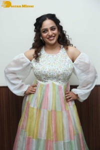 Nithya Menen in a white top and colorful skirt attending a movie function