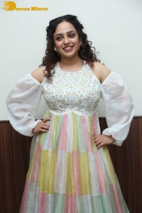 Nithya Menen in a white top and colorful skirt attending a movie function