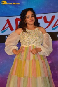 Nithya Menen in a white top and colorful skirt attending a movie function