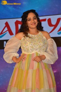 Nithya Menen in a white top and colorful skirt attending a movie function