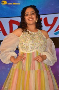 Nithya Menen in a white top and colorful skirt attending a movie function