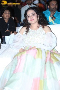 Nithya Menen in a white top and colorful skirt attending a movie function