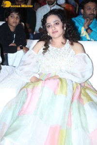 Nithya Menen in a white top and colorful skirt attending a movie function