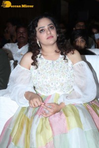 Nithya Menen in a white top and colorful skirt attending a movie function