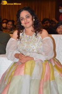 Nithya Menen in a white top and colorful skirt attending a movie function