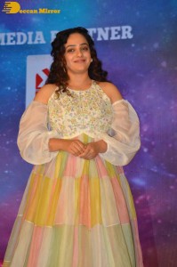 Nithya Menen in a white top and colorful skirt attending a movie function