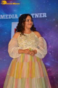 Nithya Menen in a white top and colorful skirt attending a movie function