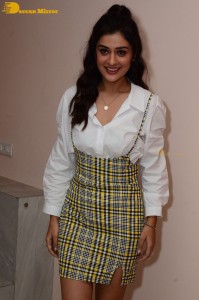 Actress Payal Rajput poses for pictures in a white shirt and yellow skirt
