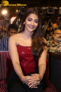 Pooje Hegde in a red shoulderless top and black pants while attending a movie funciton